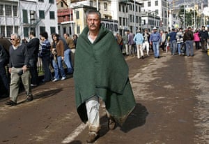 madeira: Man covered in a blanket walks in Funchal after flooding in MAdeira