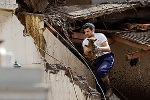 madeira: A man retrieves a small dog from a house wrecked by a mudslide in Funchal  