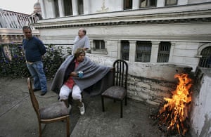 Chile Earthquake: Victims of the huge earthquake sit by a fire in Valparaiso 