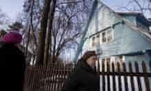 People walk past an old house at the Sokol Village, Moscow