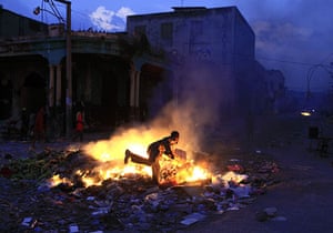 24 hours in pictures: Port-au-Prince, Haiti: A youth feeds a fire