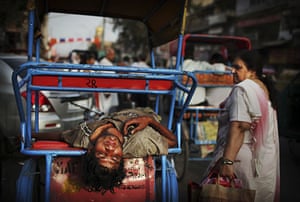 24 Hours in Pictures: An Indian rickshaw driver takes a nap in the afternoon heat in New Delhi