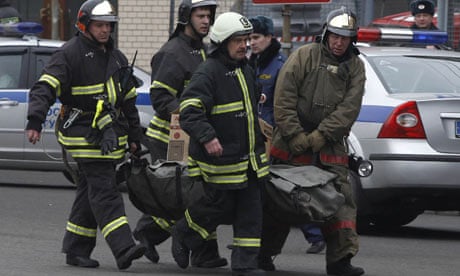 Firefighters carry a body from Lubyanka metro station to an ambulance in Moscow
