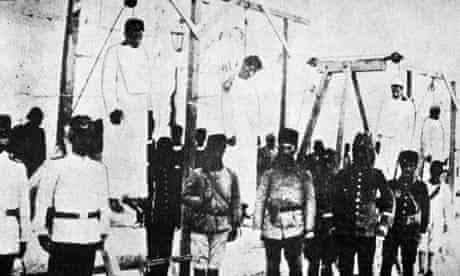 Ottoman soldiers pose with hanged Armenians