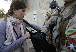 Elections in Iraq: An Iraqi soldier searches a woman's purse