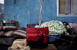 24 hours in pictures: Talcahuano, Chile: A woman sleeps outside her house in Talcahuano