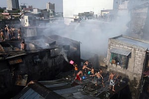 24 hours in pictures: Pasay City, Philippines: People help to put out a fire