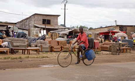 A man cycles past furniture for sale at the roadside in Cameroon.