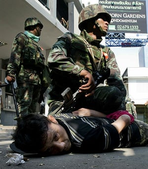Thailand protests: An anti-government protester is detained by military forces