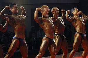 24 Hours in Pics: Participants pose on stage during the bodybuilding competition in Hefei