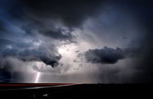 24 hours in pictures: Pendleton, USA: Lightning strikes as a car drives north on Highway 11