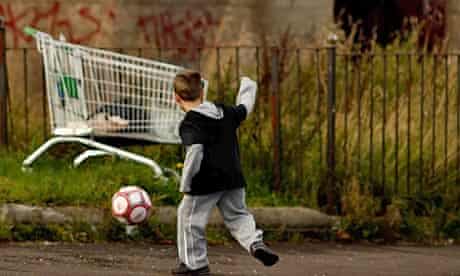 A young boy playing football in a street in Govan, Glasgow