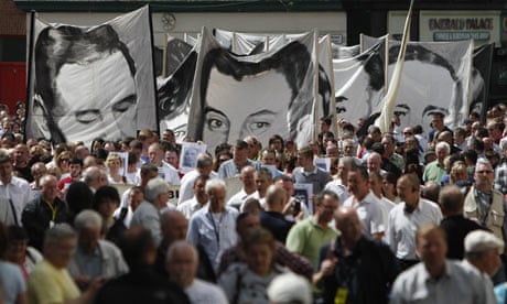 Banners bearing portraits of Bloody Sunday victims are carried to the Guildhall.