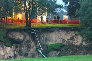 Sinkholes: 2002, Orlando, US: Emergency personnel stand by a giant sinkhole
