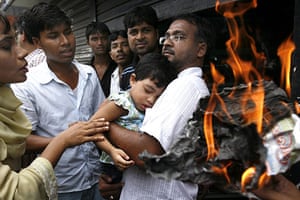 Dhaka protests: A Bangladeshi child is comforted after inhaling smoke from burning papers