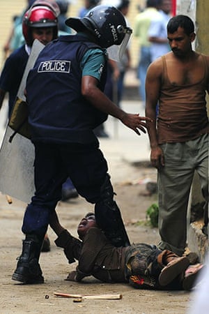 Dhaka protests: A Bangladeshi policeman kicks a child during clashes with garment workers