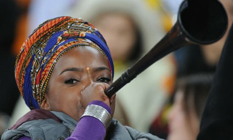 A supporter blows a vuvuzela prior to th