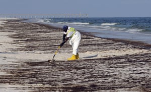 Deepwater Horizon: BP oil spill: crew member works to clean up oil washed ashore 
