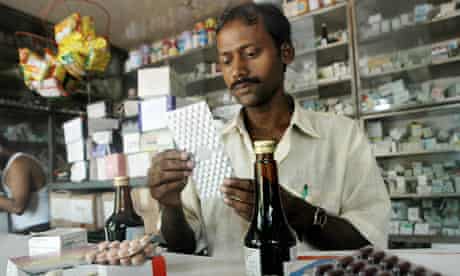 An Indian pharmacy assistant counts tablets