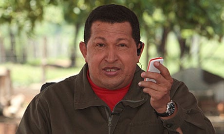 Hugo Chavez holds a mobile phone
