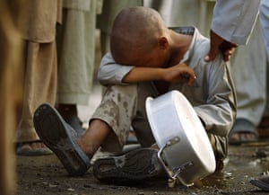 Pakistan Flood Update: A boy sitting on the ground cries while waiting for food