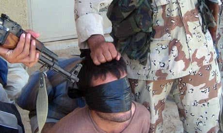 Iraqi soldiers guard a blindfolded detainee during an operation outside Baquba, north of Baghdad