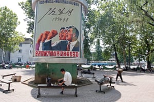 North Korea: Pyongyang street with one of North Korea's ubiquitous propaganda posters