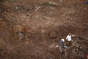 Mexico landslides: Men stand at the site of a landslide that buried homes