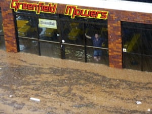 Floods in Australia: A man watches from in a lawn mower business in Toowoomba