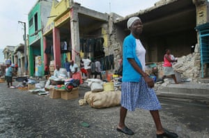 Haiti then and now: January 2011: A woman walks past the previously looted building