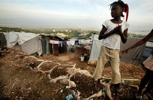 Haiti then and now: January 2011: A girl looks on in an expanded tent city 