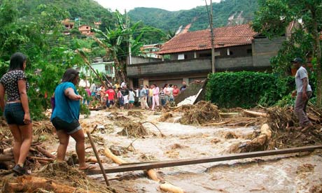 Women trying to cross a river after landslides in Brazil