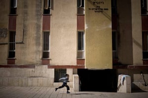 24 hours in pictures: An ultra-Orthodox Jewish boy runs past a building in Beni Brak, Israel
