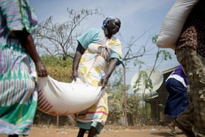 24 hours in pictures: Sudanese women unload sacks of food during a distribution