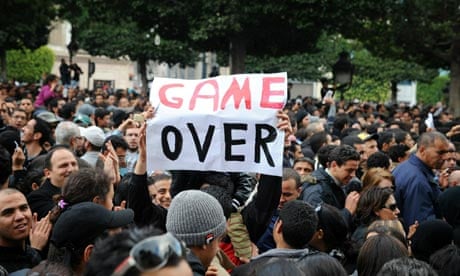 A Tunisian demonstrator holds a placard reading "Game Over" during a rally at the interior ministry