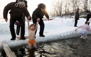 Orthodox epiphany: Russian Orthodox Christians lower a young girl  into the Moskva river