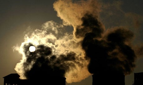 Smoke billows from a factory during sunset in Spanish town of Torrelavega.