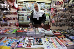 Tunisia Protests: A store owner stands behind newpapers and magazines