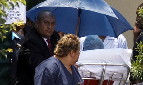Former South African president Nelson Mandela (under umbrella) leaves hospital in Johannesburg