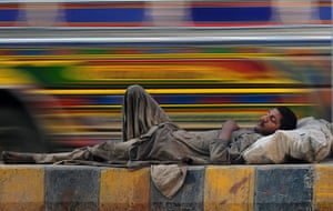 24 hours: Karachi, Pakistan: A Pakistani homeless man rests on on a road 
