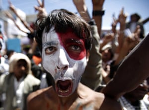 24 hours: Sanaa, Yemen: An anti-government protester with his face painted 