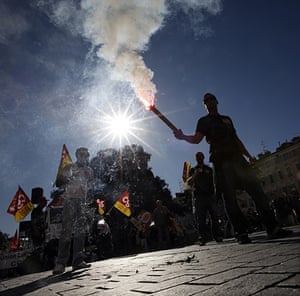 24 hours: Nice, France: A man holds a flare during a national day of protest 