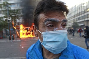 Greece strikes & protests: A protester walks past a kiosk set alight by protesters during clashes