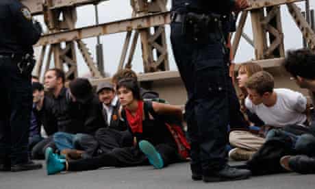 Protesters sit in plastic handcuffs on the Brooklyn Bridge during an Occupy Wall Street march