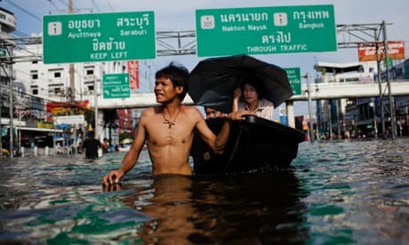 Thai residents make their way through a flooded street in Pathum Thani, Thailand.