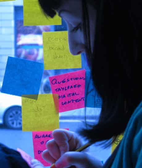 A student designer writing a Post-It note