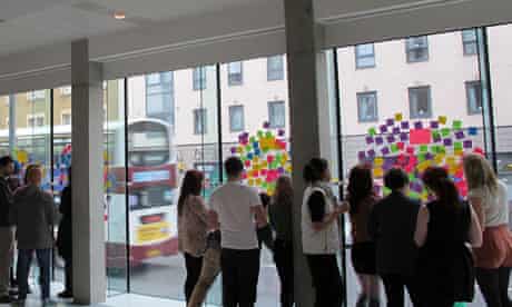 A group of student designers developing ideas using Post-It notes