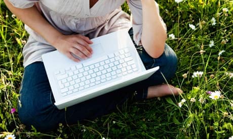 Woman with laptop in wild meadow