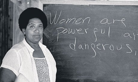 Audre Lorde in front of a blackboard that says 'Women are powerful and dangerous'