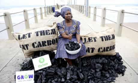 Oxfam activist pretends to eat coal in a protest outside the Durban talks